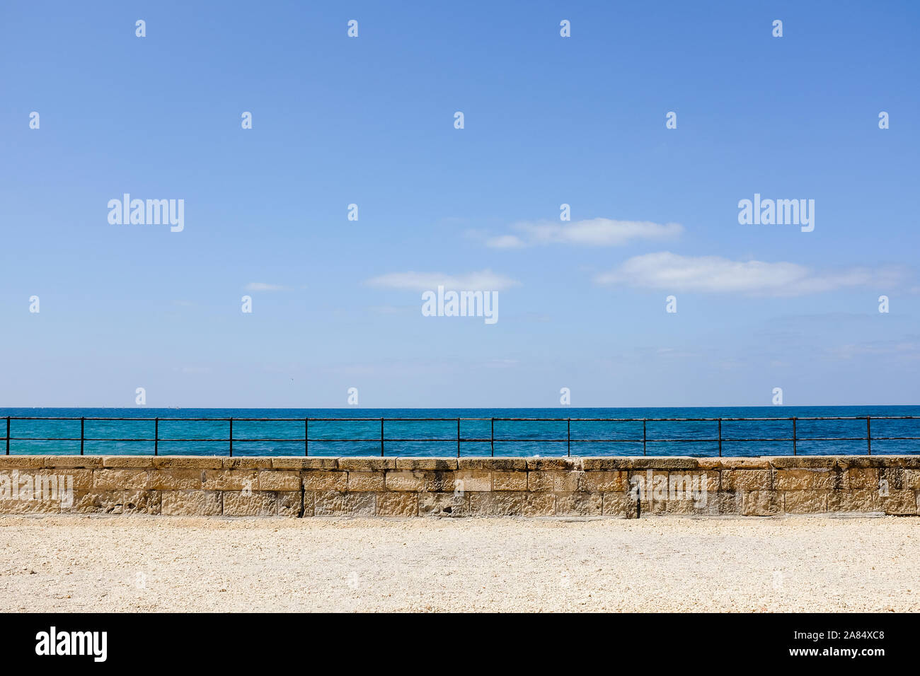 Horizontale Sicht auf Meer, Himmel, Geländer und Sand Stockfoto