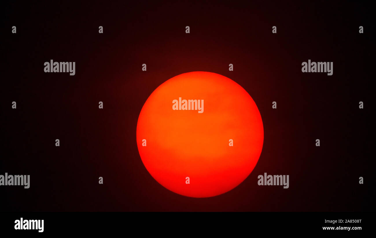 Rote Sonnenkugel in dickem Smog Stockfoto