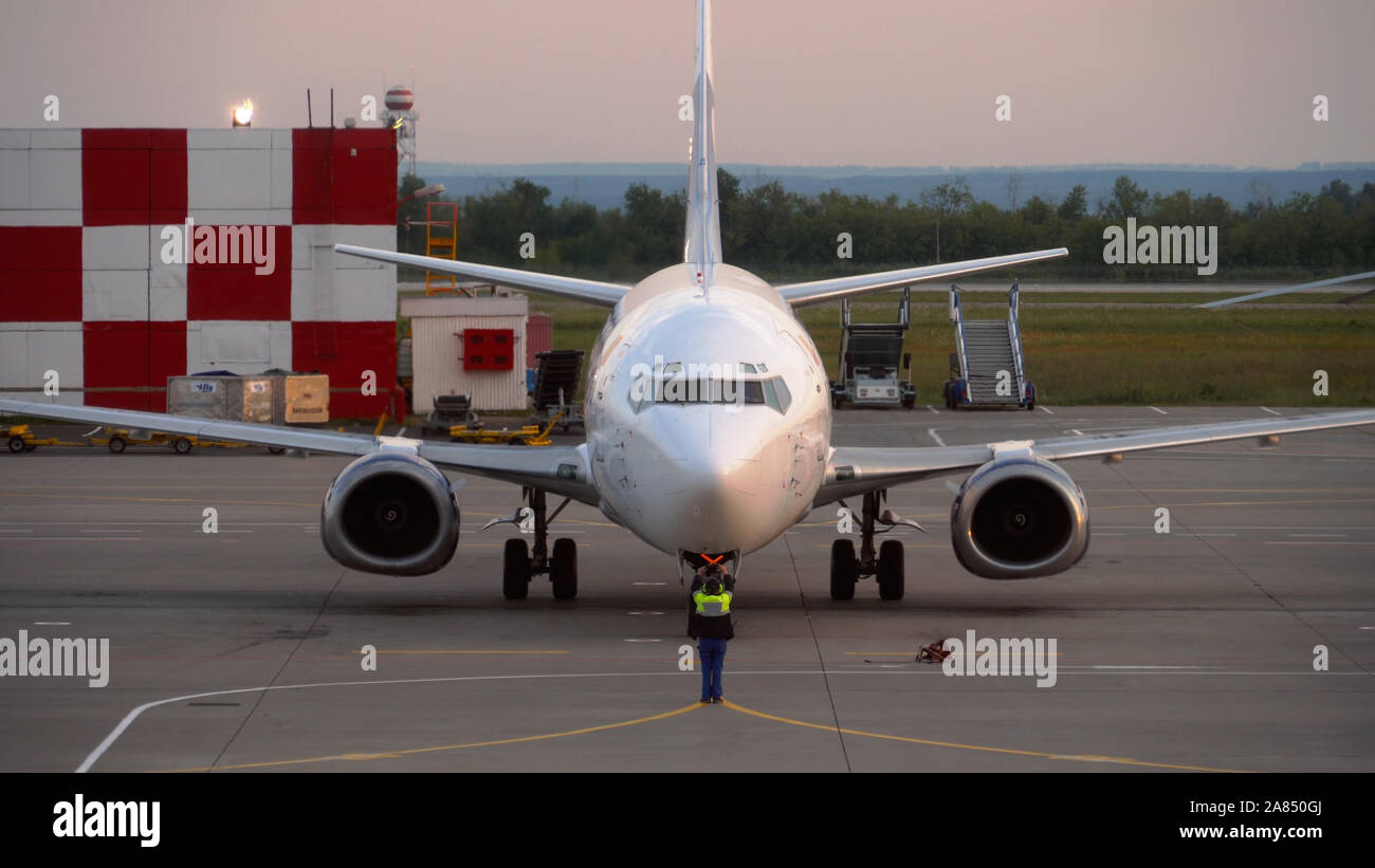 Der Aufseher trifft das Passagierflugzeug am Flughafen Stockfoto