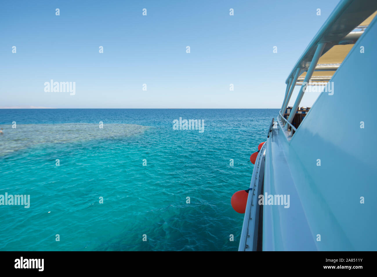 Sehen Sie auf die Seite der Luxury Motor Yacht auf See mit tropical ocean view und Coral Reef Stockfoto