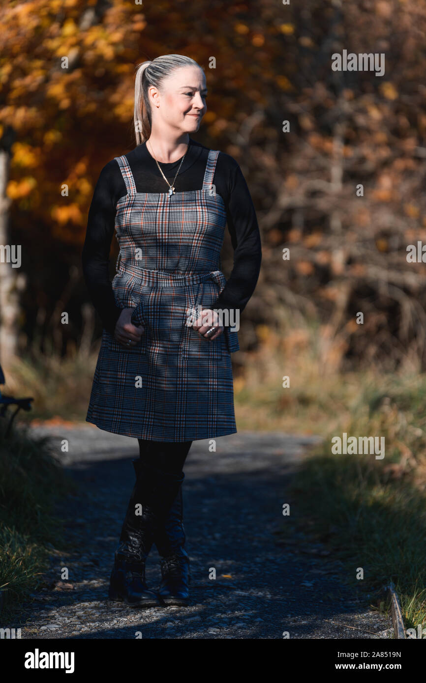 Porträt einer schönen Frau in den 40ern mit Herbst Blätter und Farben im Hintergrund Stockfoto