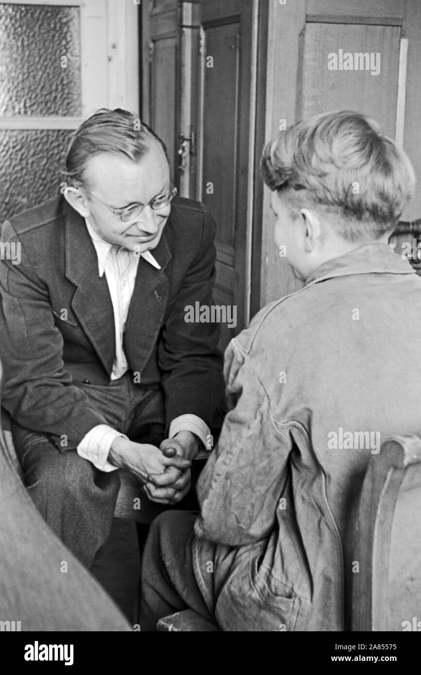 Der geistliche Beistand redet mit einem Häftling in einem Büro, Justizvollzugsanstalt Herford Deutschland 1950. Der Geistliche ist ein Gespräch mit einem Häftling im Büro, in der Justizvollzugsanstalt Herford Deutschland 1950. Stockfoto