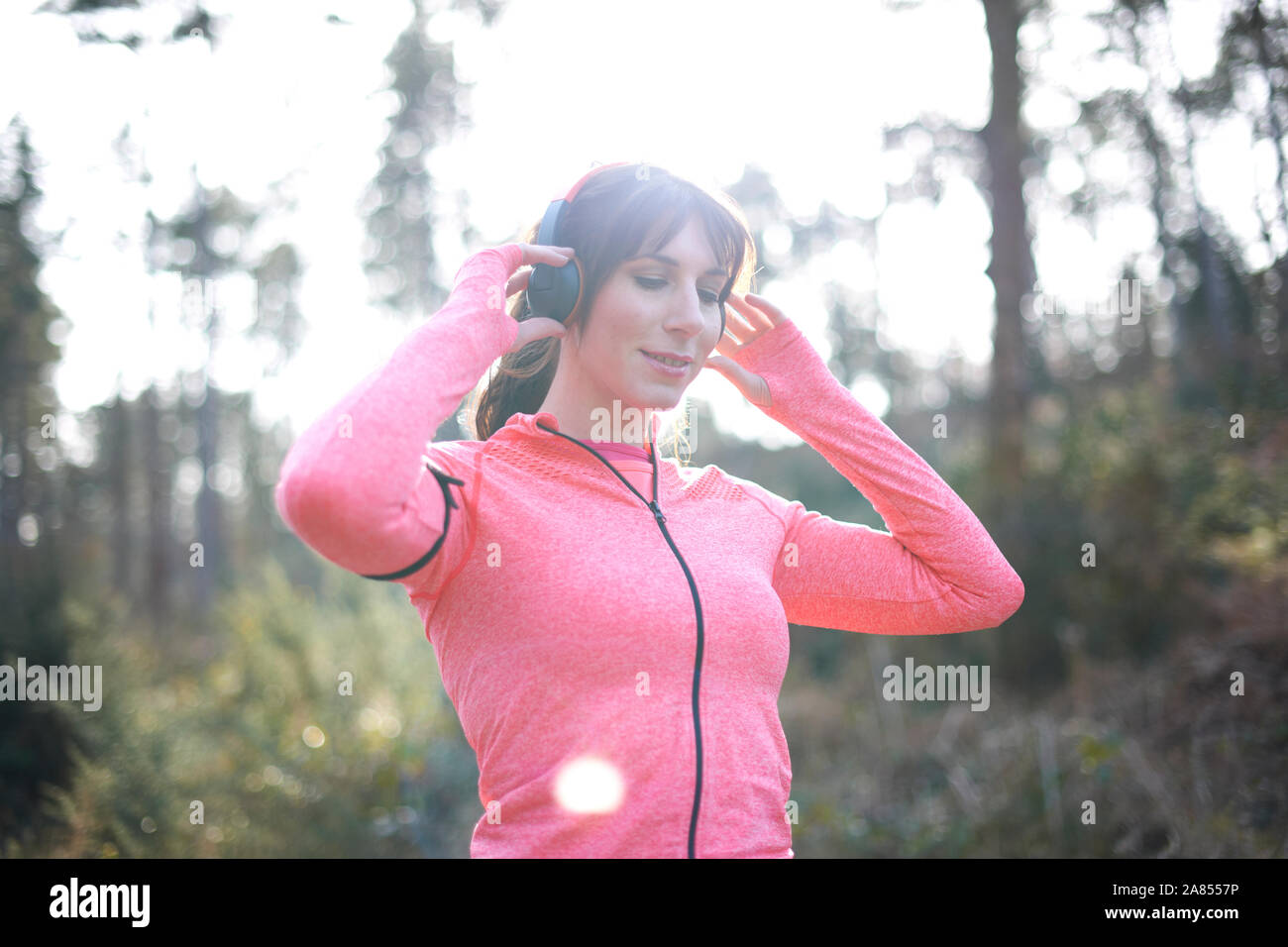 Läuferin mit Kopfhörern in Wäldern Stockfoto