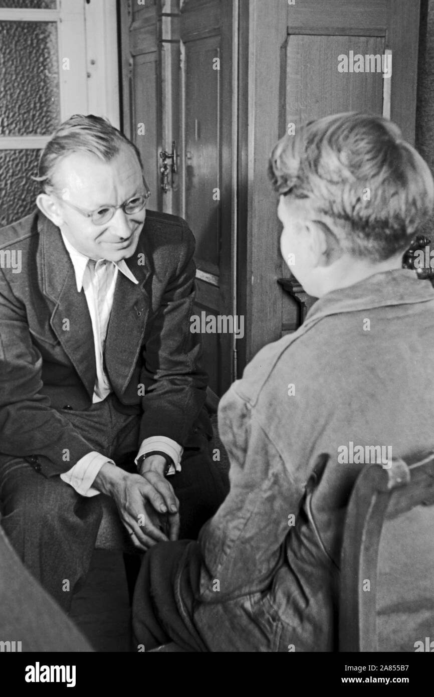 Der geistliche Beistand redet mit einem Häftling in einem Büro, Justizvollzugsanstalt Herford Deutschland 1950. Der Geistliche ist ein Gespräch mit einem Häftling im Büro, in der Justizvollzugsanstalt Herford Deutschland 1950. Stockfoto