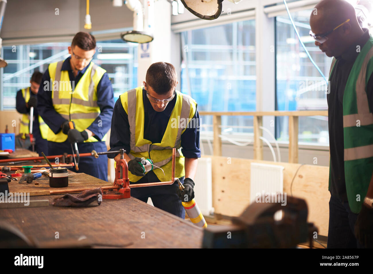 Männliche Kursleiter beobachten student Schweißen in Werkstatt Stockfoto