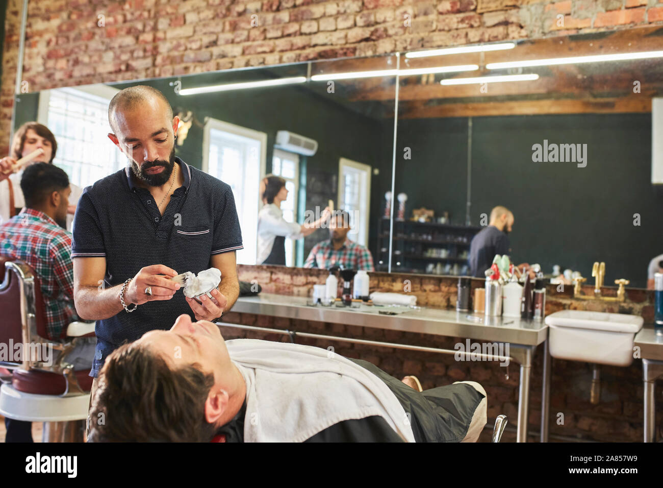 Männliche friseur Vorbereitung Gesicht der Kunden in der barbier Rasieren Stockfoto