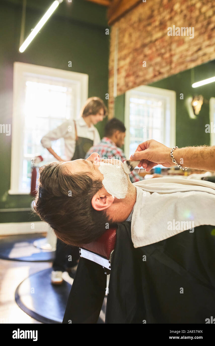 Man erhält eine Rasur in Barbershop Stockfoto