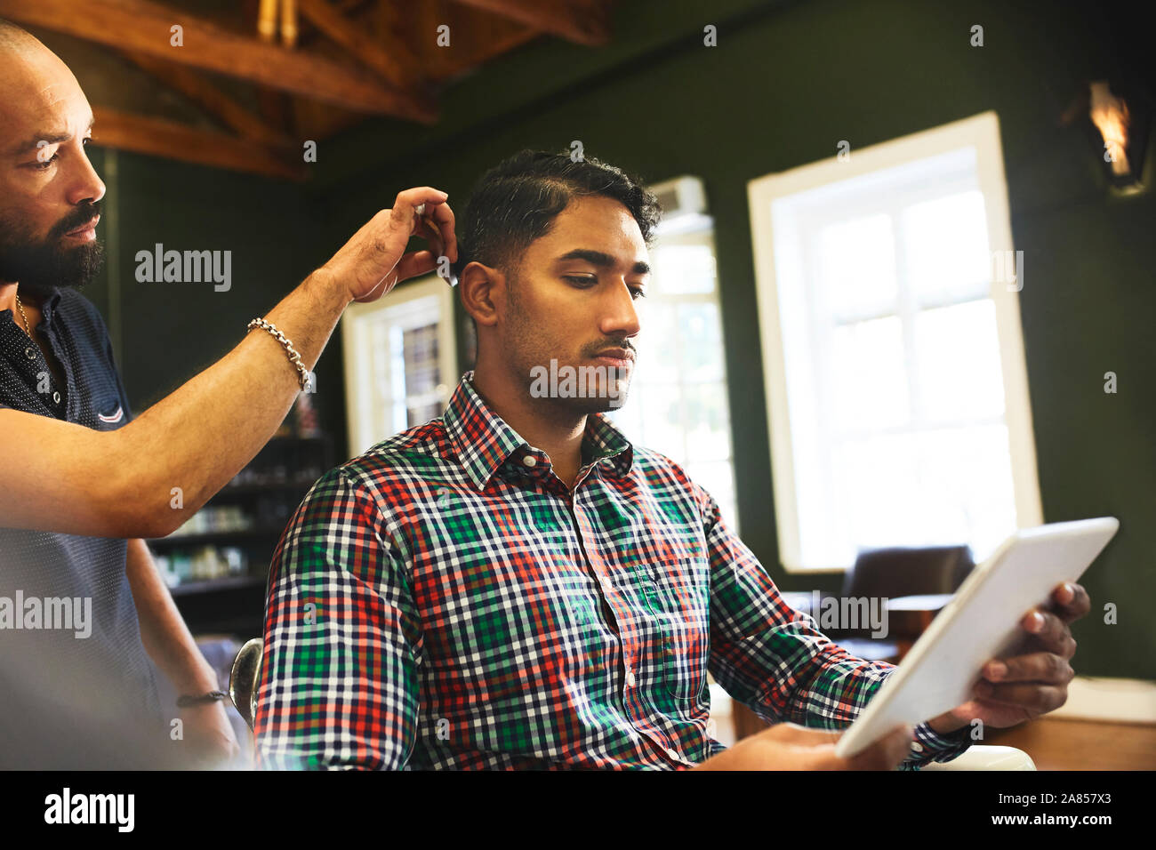 Mann mit digitalen Tablet während der HAARSCHNITT im barbershop Stockfoto
