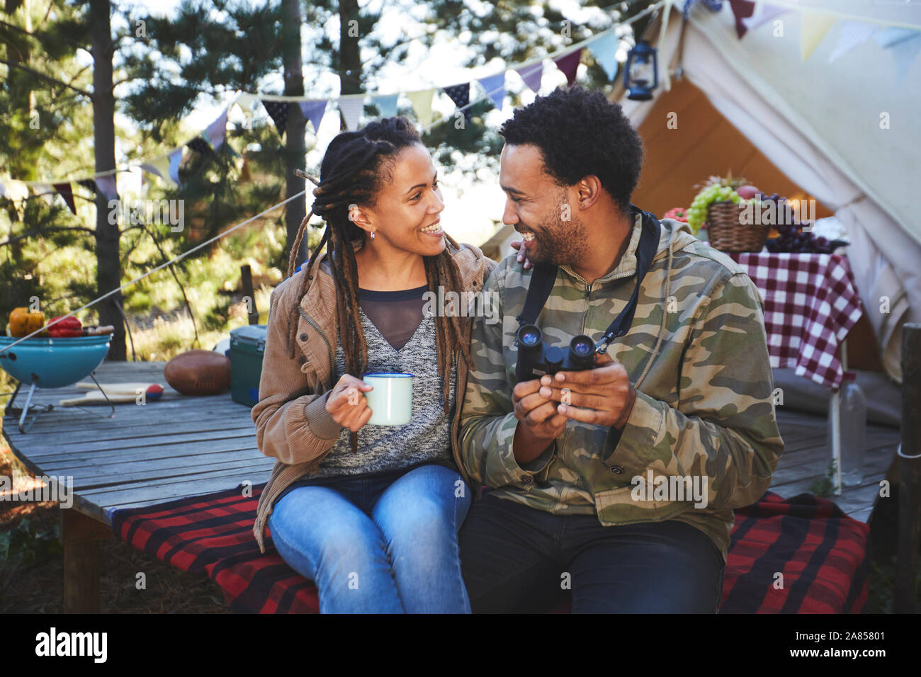 Herzlichen junges Paar mit Fernglas Kaffee trinken am Campingplatz Stockfoto