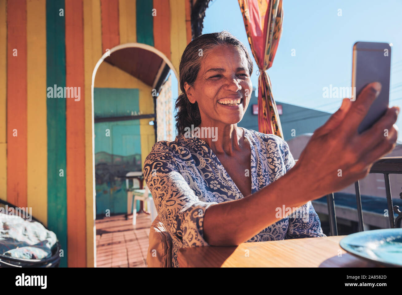 Lächelnd, glücklich, Frau unter selfie mit Smart Phone auf der sonnigen Terrasse Stockfoto