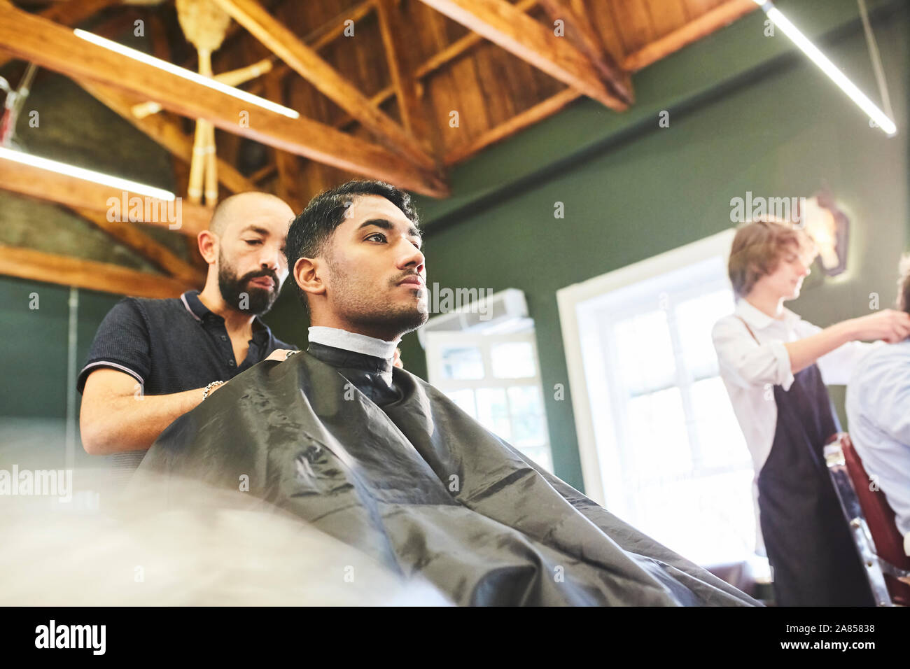 Männliche Kunde bekommt einen Haarschnitt in Barbershop Stockfoto