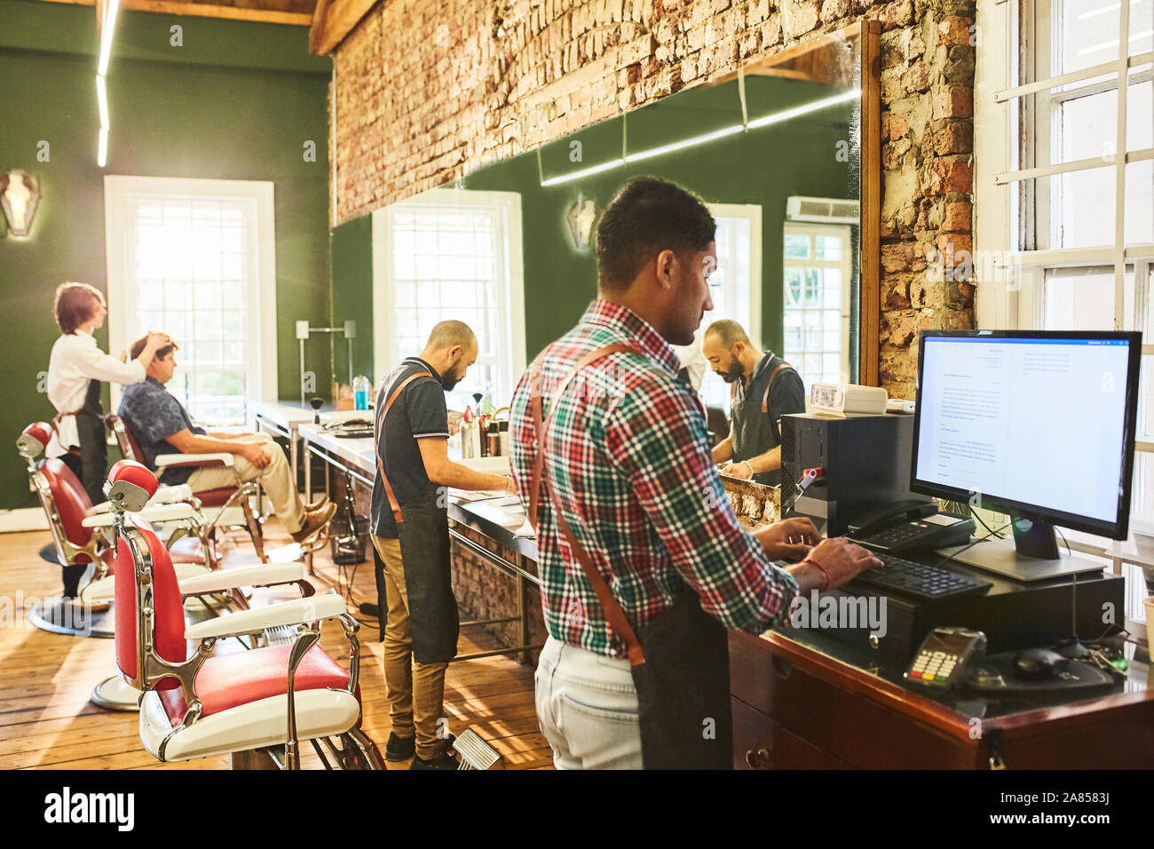 Männliche Friseure arbeiten in Barbershop Stockfoto