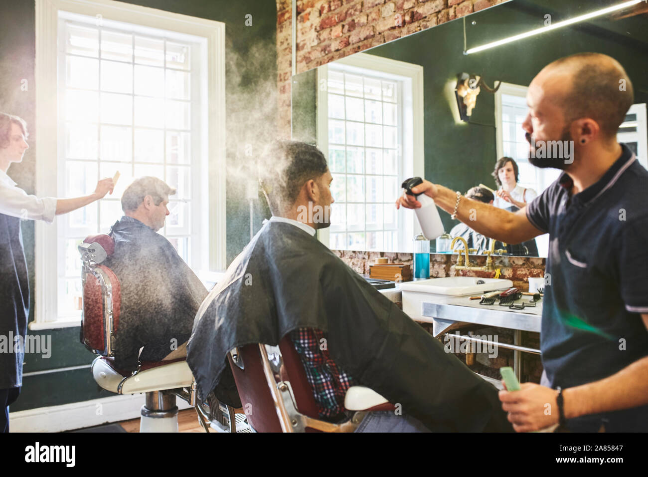 Männliche Friseur Haar sprühen der Kunden in der Barbershop Stockfoto