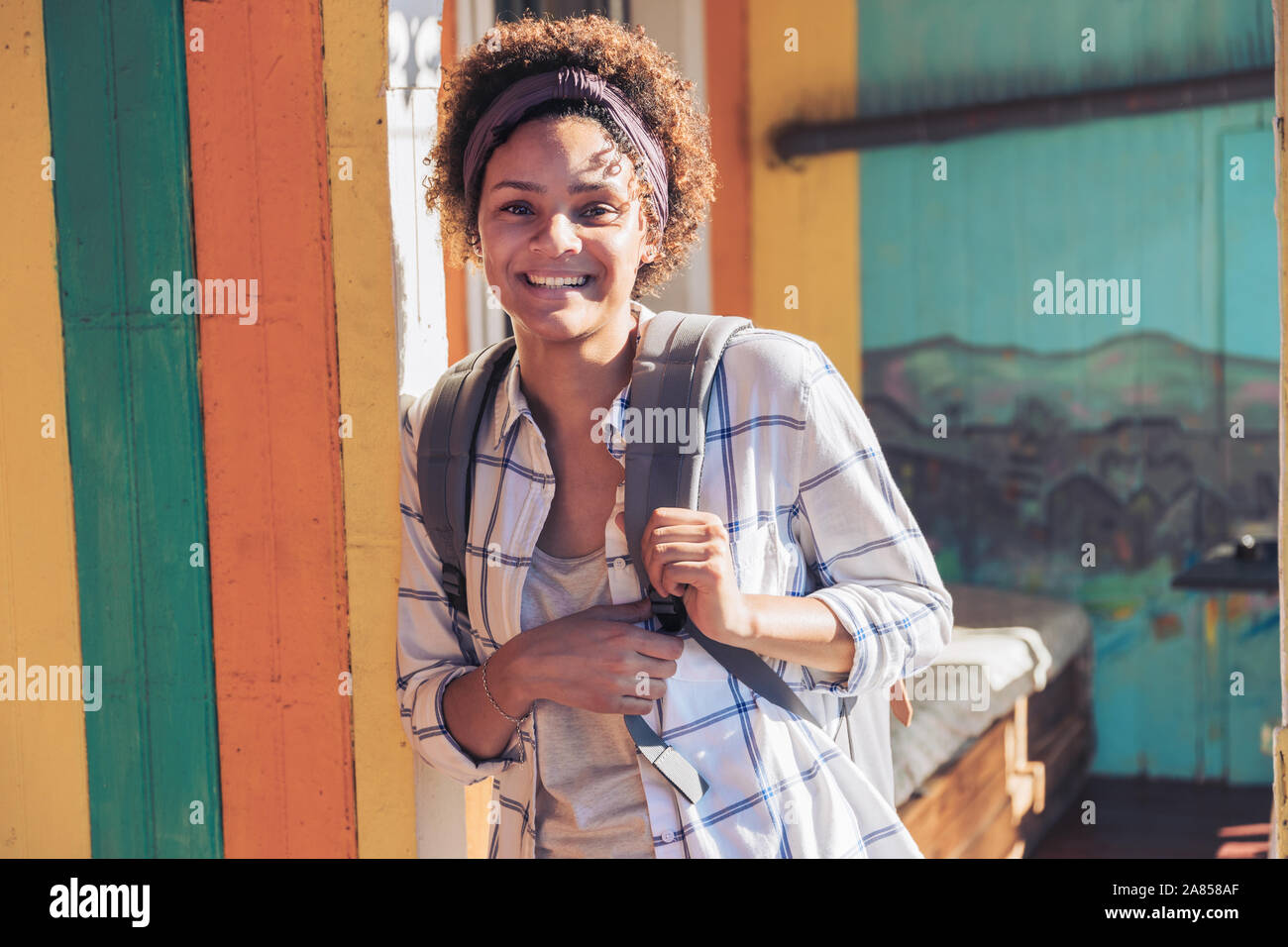 Porträt Lächeln, selbstbewussten jungen Frau, die auf der sonnigen Terrasse Stockfoto