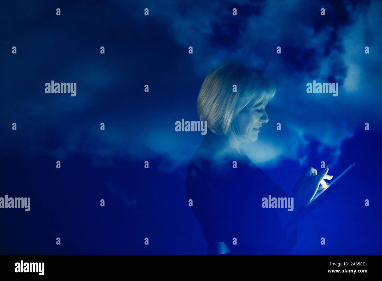 Double Exposure Geschäftsfrau mit digitalen Tablette gegen den blauen Himmel mit Wolken Stockfoto