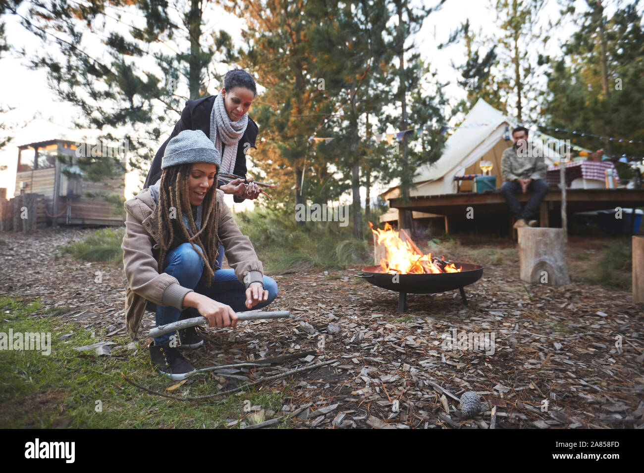 Freunde Sammeln von Brennholz Kleinholz auf einem Campingplatz im Wald Stockfoto
