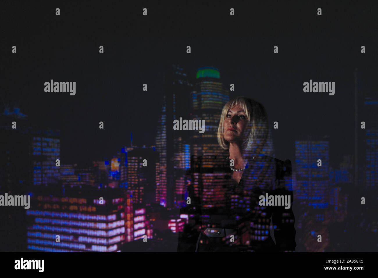 Double Exposure nachdenklich Geschäftsfrau gegen Hochhaus Lichter in der Nacht Stockfoto