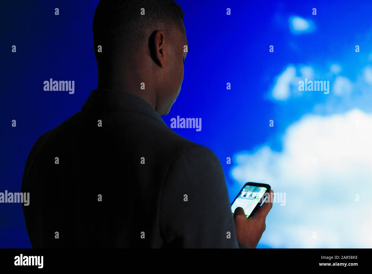 Double Exposure Geschäftsmann mit smart phone gegen den blauen Himmel mit Wolken Stockfoto