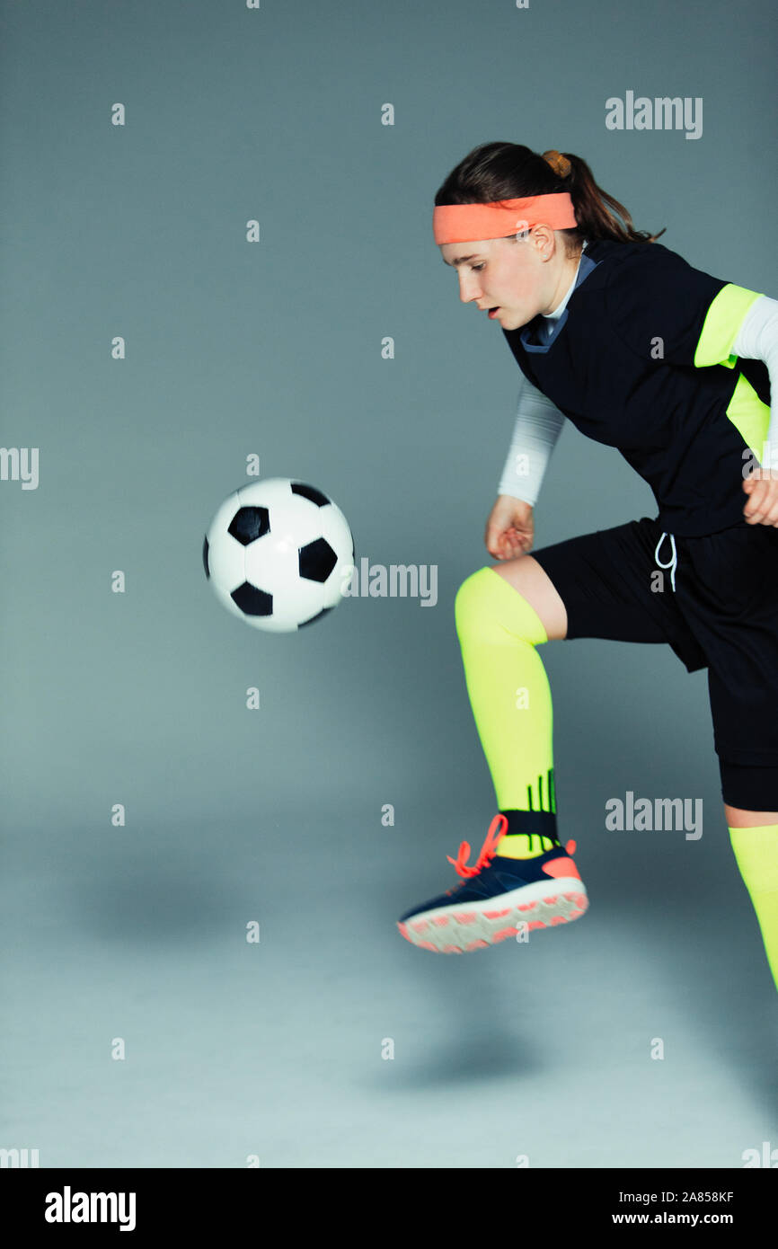 Junges Mädchen Fußball-Spieler kicken den Ball Stockfoto