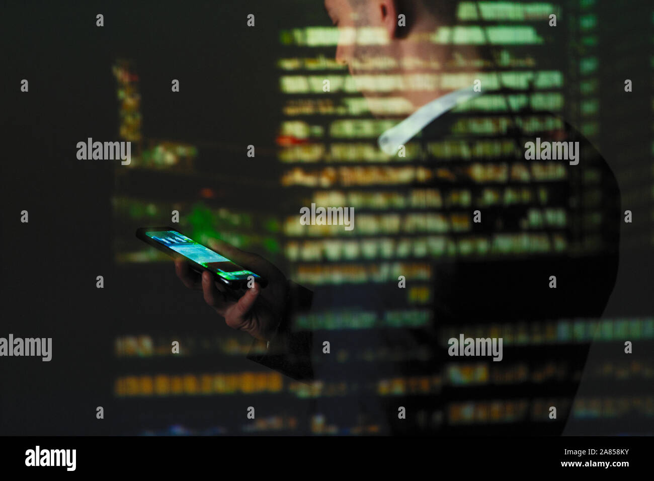 Double Exposure Geschäftsmann mit smart phone gegen Hochhaus in der Nacht Stockfoto