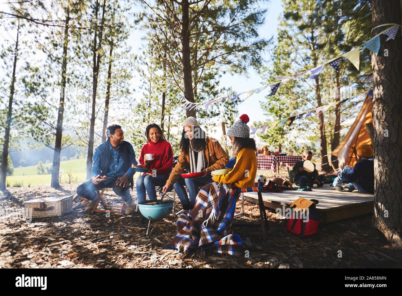 Familie kochen Camping Grill in Sunny woods Stockfoto