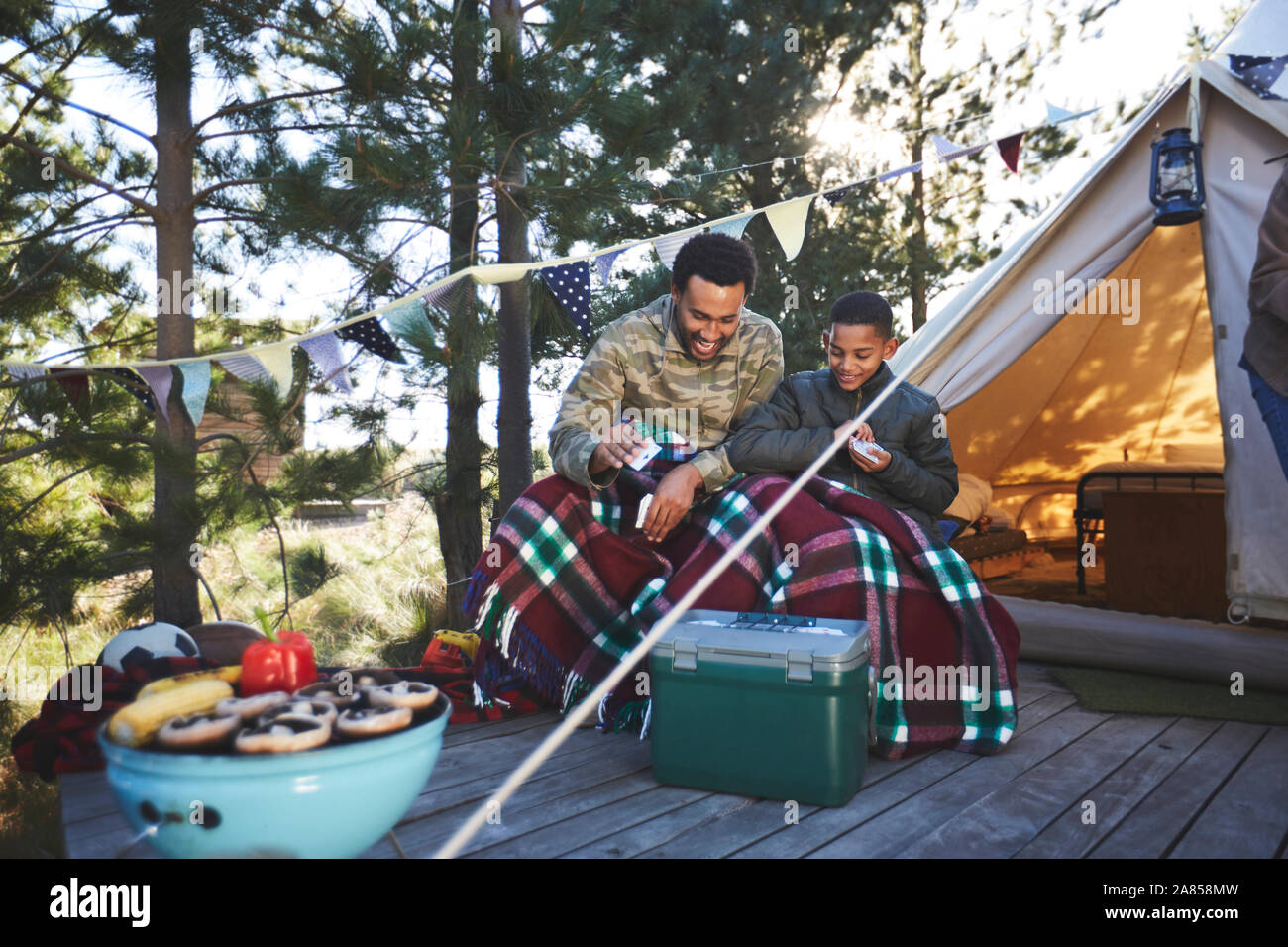 Vater und Sohn Karten außerhalb Jurte auf dem Campingplatz Stockfoto