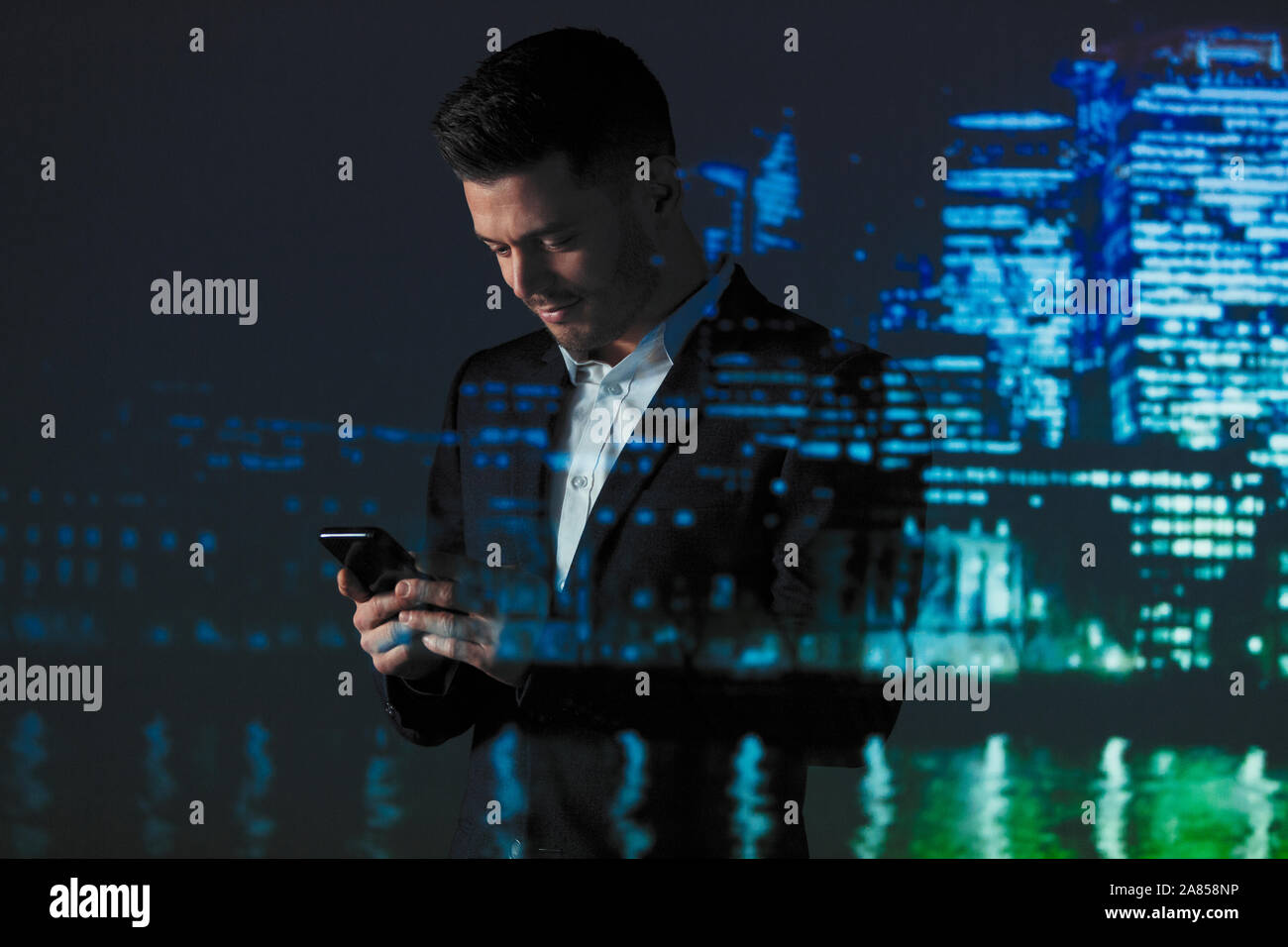 Double Exposure Geschäftsmann mit smart phone gegen Hochhaus Lichter in der Nacht Stockfoto