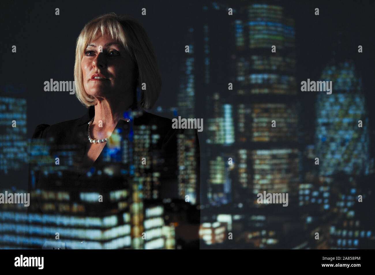 Double Exposure nachdenklich Geschäftsfrau gegen Hochhaus Lichter in der Nacht Stockfoto