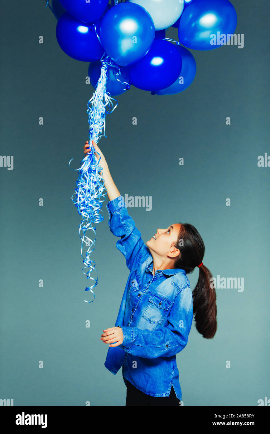 Tween girl Holding blauen Ballon Bündel Stockfoto