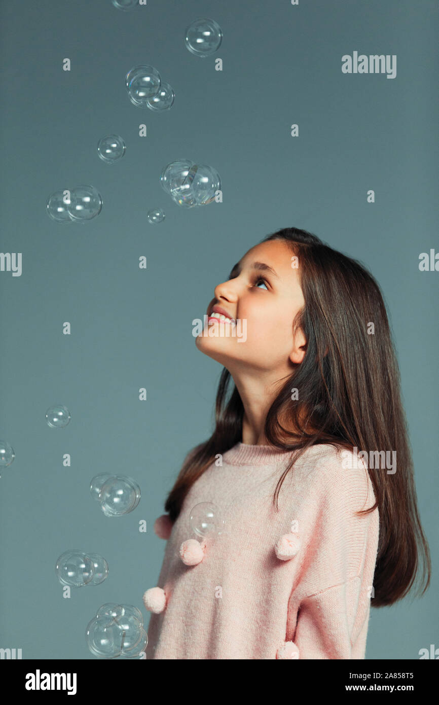 Glücklich, neugierig Mädchen fallen Blasen beobachten Stockfoto