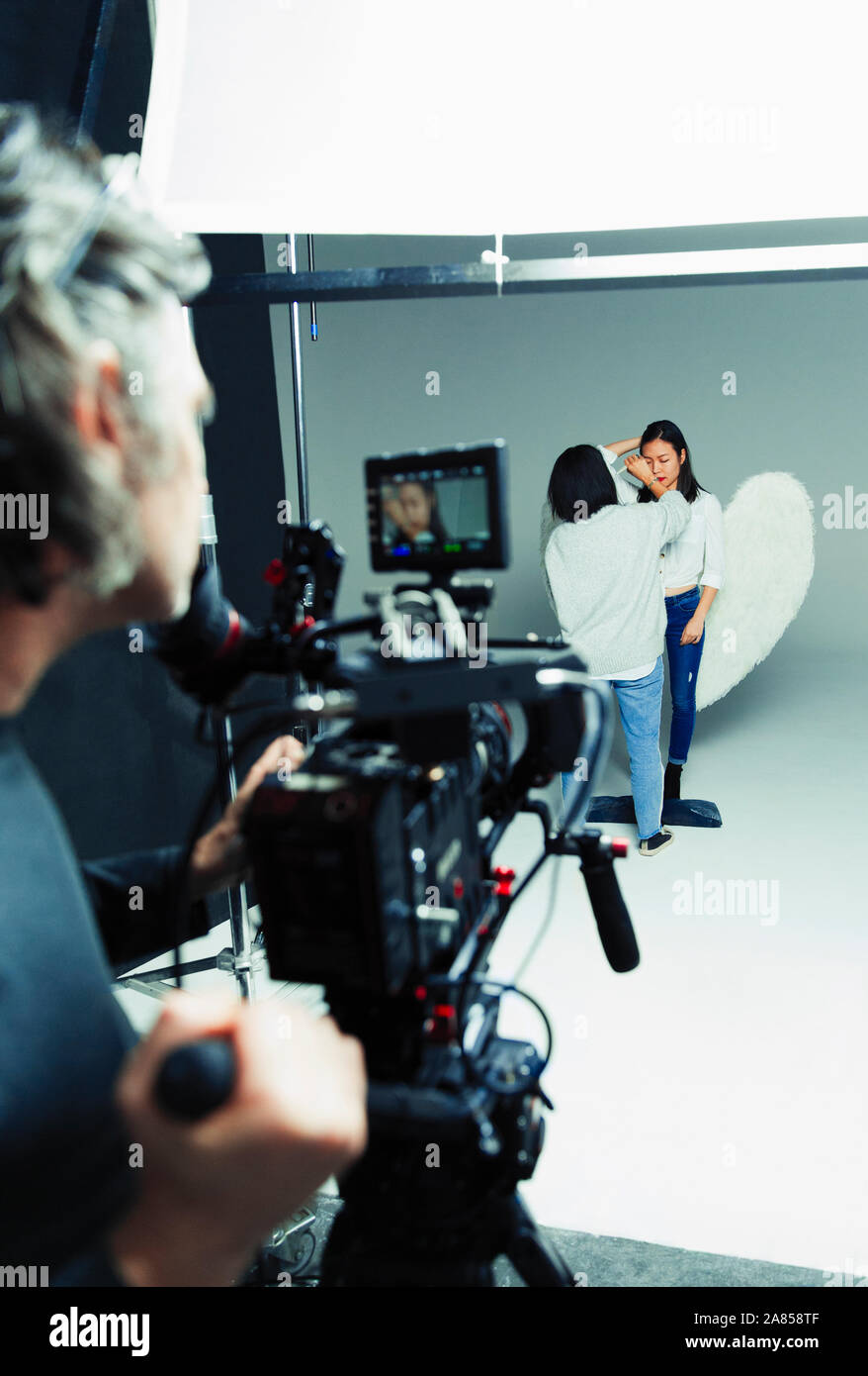 Fotografen warten auf Make-up-Artist und Modell in Angel Wings während studio Foto schießen Stockfoto