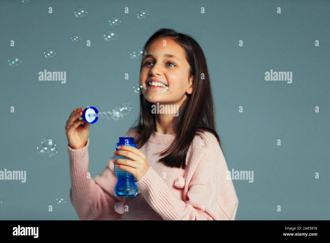 Fröhlicher, verspielter Mädchen mit Bubble wand bläst Seifenblasen Stockfoto