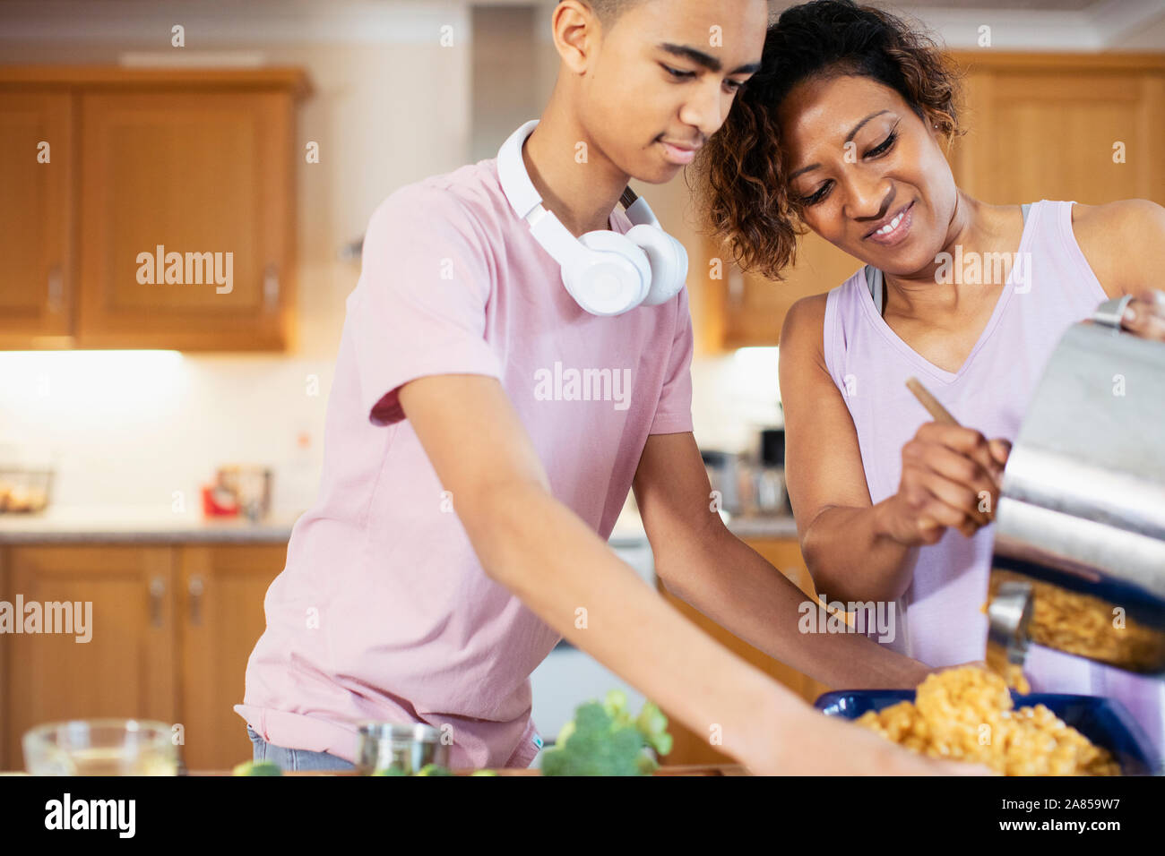 Mutter und Sohn im Teenageralter Kochen in der Küche Stockfoto