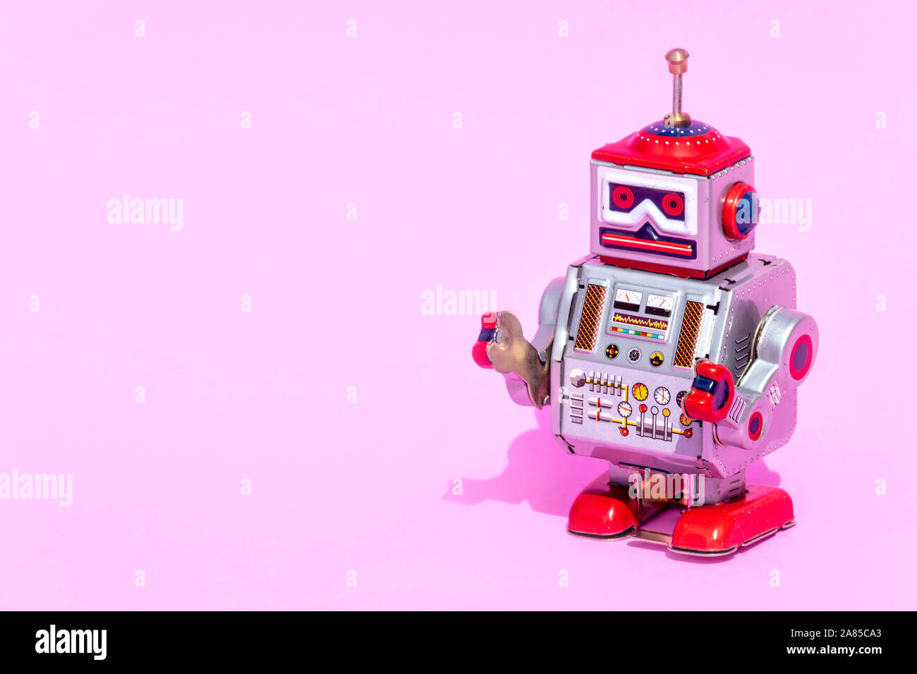 Antique Tin Toy Roboter auf rosa Hintergrund. Oldtimer Konzept kostenlose Kopie Platz für Text. Stockfoto