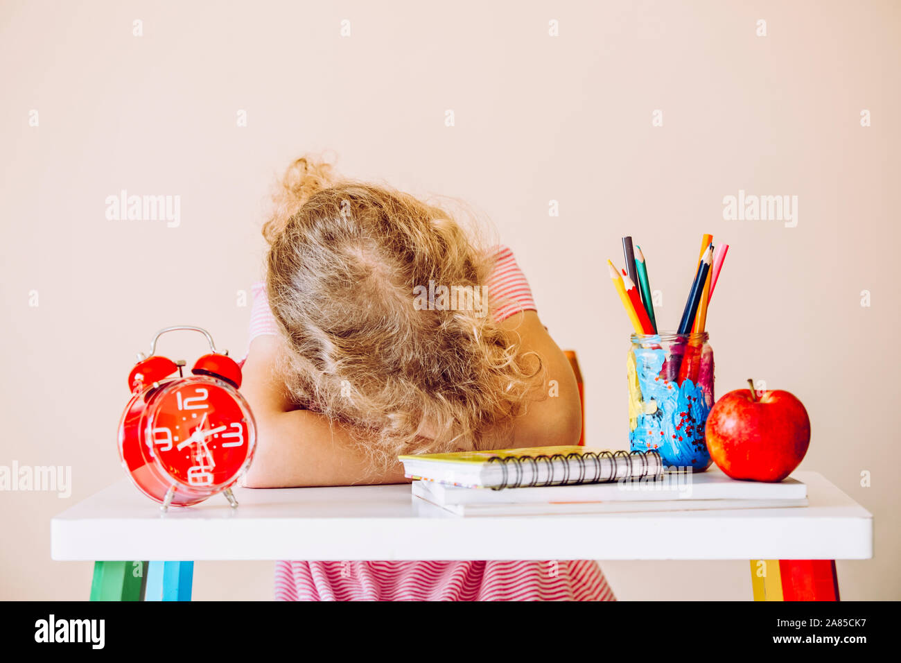 Junge Kind Schüler sitzen am Tisch und Schlafen im Klassenzimmer oder zu Hause. Müde und gelangweilt. Stockfoto