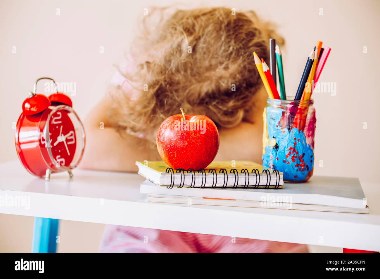 Junge Kind Schüler sitzen am Tisch und Schlafen im Klassenzimmer oder zu Hause. Müde und gelangweilt. Stockfoto