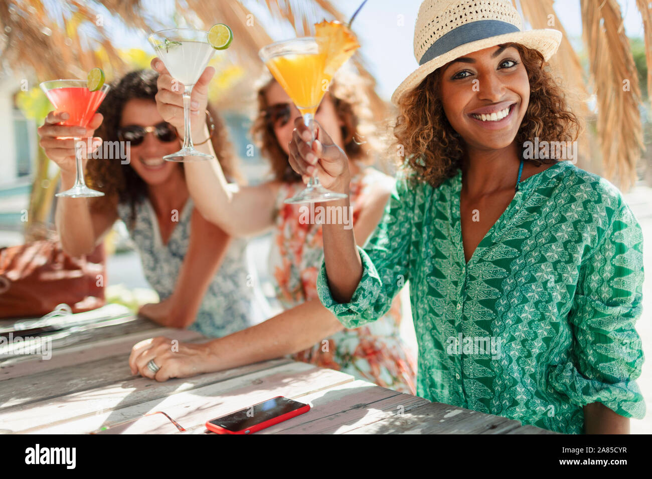 Portrait glückliche Frauen Freunde mit Cocktails in Sunny Beach Bar Stockfoto