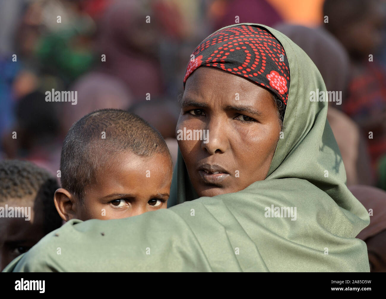 Nach dem Trekking für einen Monat über Ostafrika, eine somalische Frau wartet mit ihrem Kind im Flüchtlingslager Dadaab im Nordosten Kenias registriert werden. Stockfoto