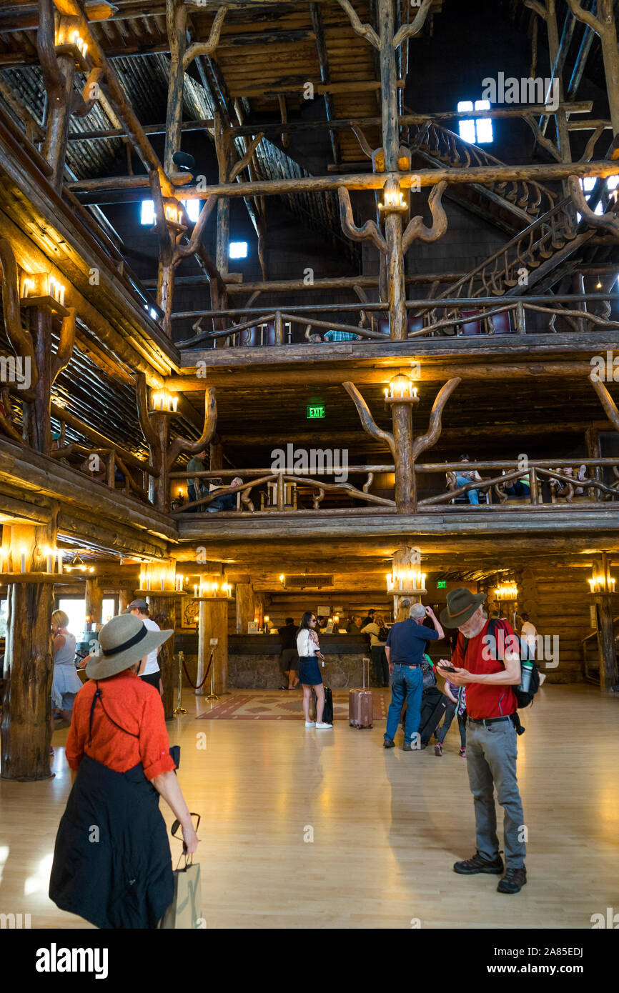 Reisende in der Lobby des historischen Old Faithful Inn, einschließlich Rezeption Stockfoto