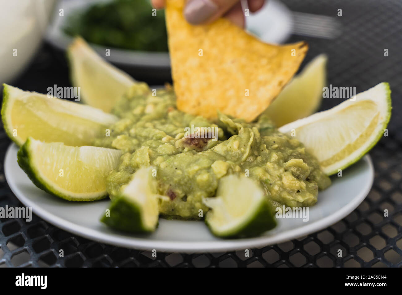 Tortilla Eintauchen in zertrümmert, Avocado, grüne Guacamole dip Stockfoto