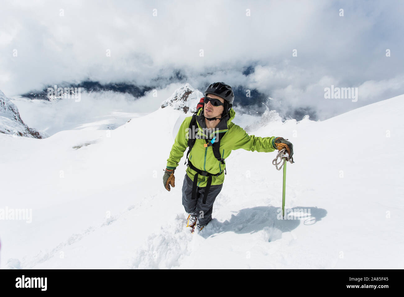 Ein junger Mann, der Aufstieg auf den Gipfel des Mt. Haube an einem bewölkten Tag. Stockfoto