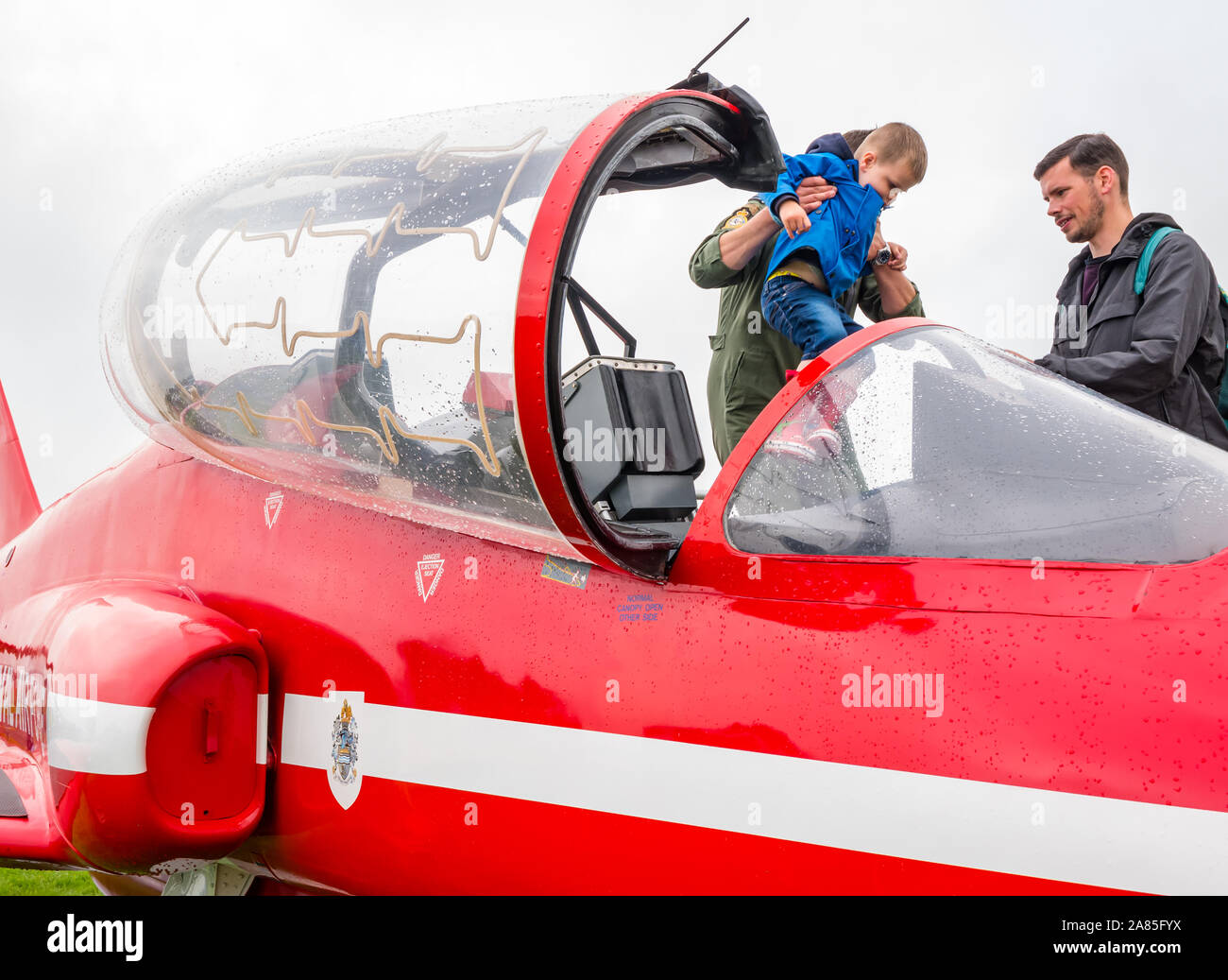 Junge sitzt in roter Pfeil BAE Systems Hawk Flugzeug auf dem Display, der Nationalen Airshow, East Fortune, East Lothian, Schottland, Großbritannien Stockfoto