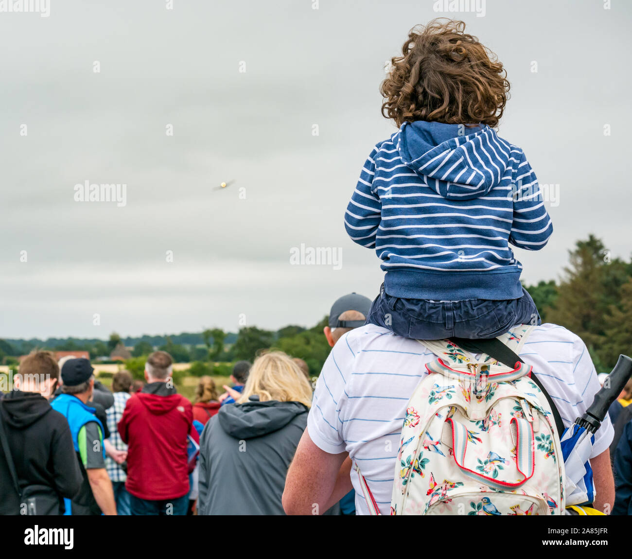 Junge sitzt auf den Schultern des Vaters ein Flugzeug auf nationaler Airshow flying zu beobachten, East Fortune, East Lothian, Schottland, Großbritannien Stockfoto