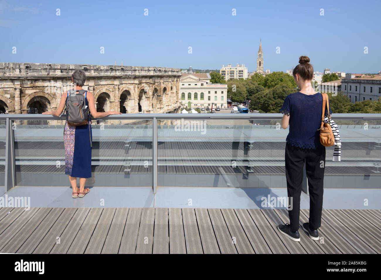 Touristen genießen den Blick von der Dachterrasse des Musée de la Romanité, oder Römischen Museum, über das römische Amphitheater oder Arena von Nimes Frankreich Stockfoto
