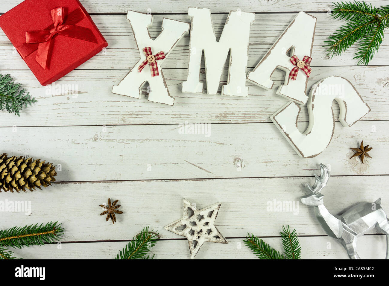 Weihnachten Rahmen Hintergrund flach auf weißem Holz mit roter Geschenkbox Weihnachten text und andere natürliche Dekoration Stockfoto