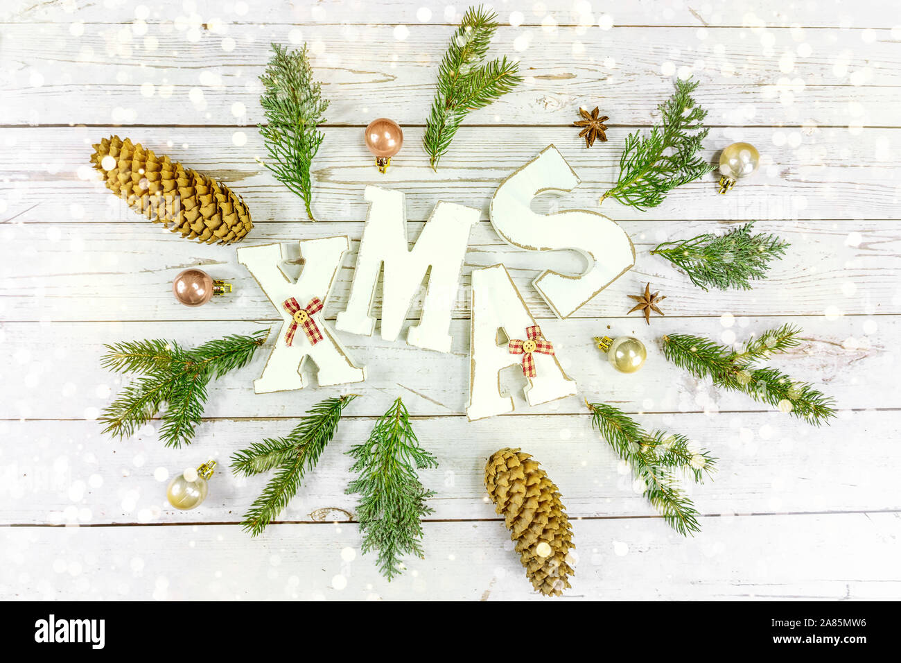Weiß Holz- Hintergrund mit weißen Weihnachten text und natürliche rustikale Dekoration mit Weihnachtsbeleuchtung bokeh Stockfoto
