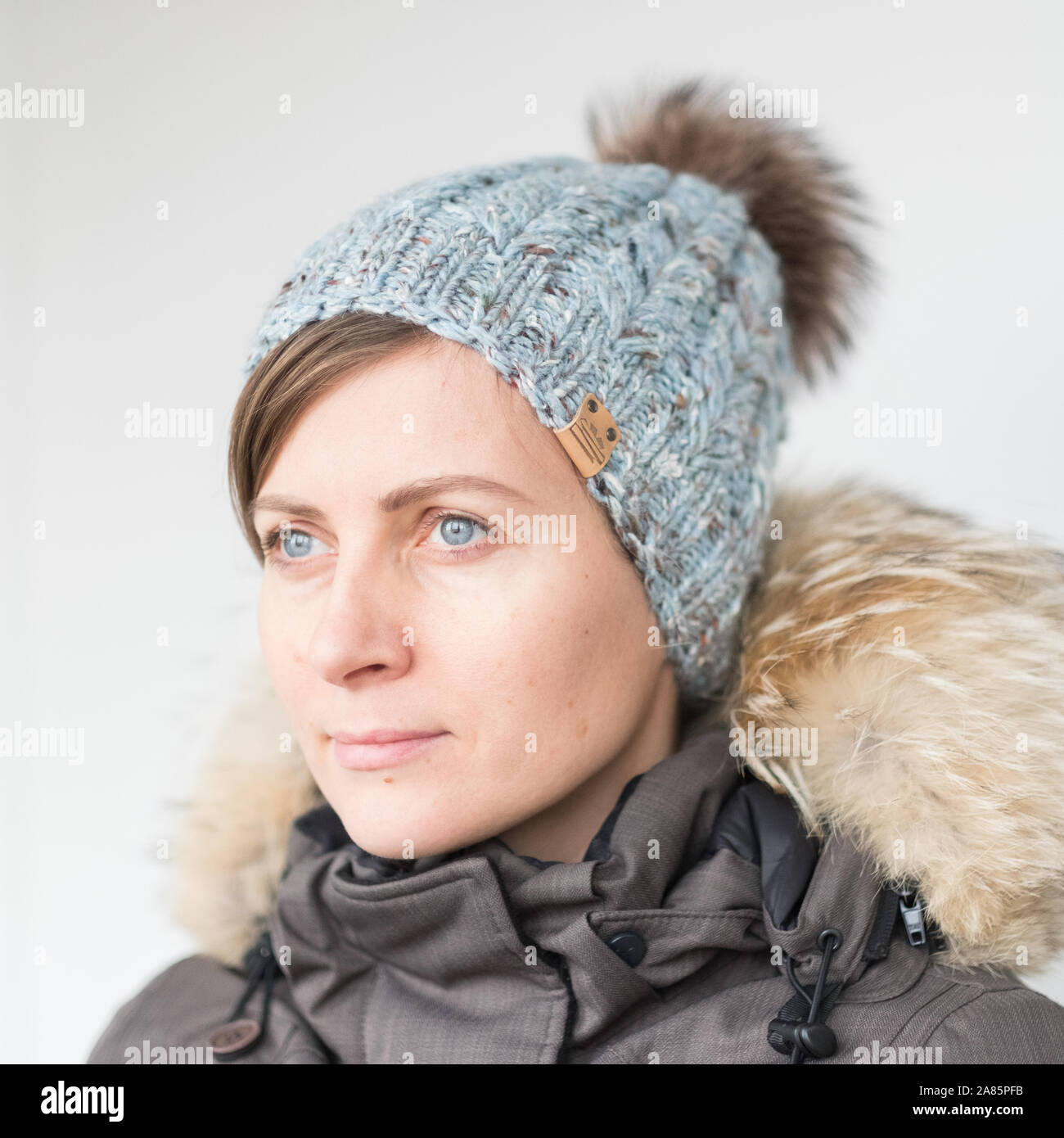 Hübsche, junge Frau mit Hut mit pom Stockfoto