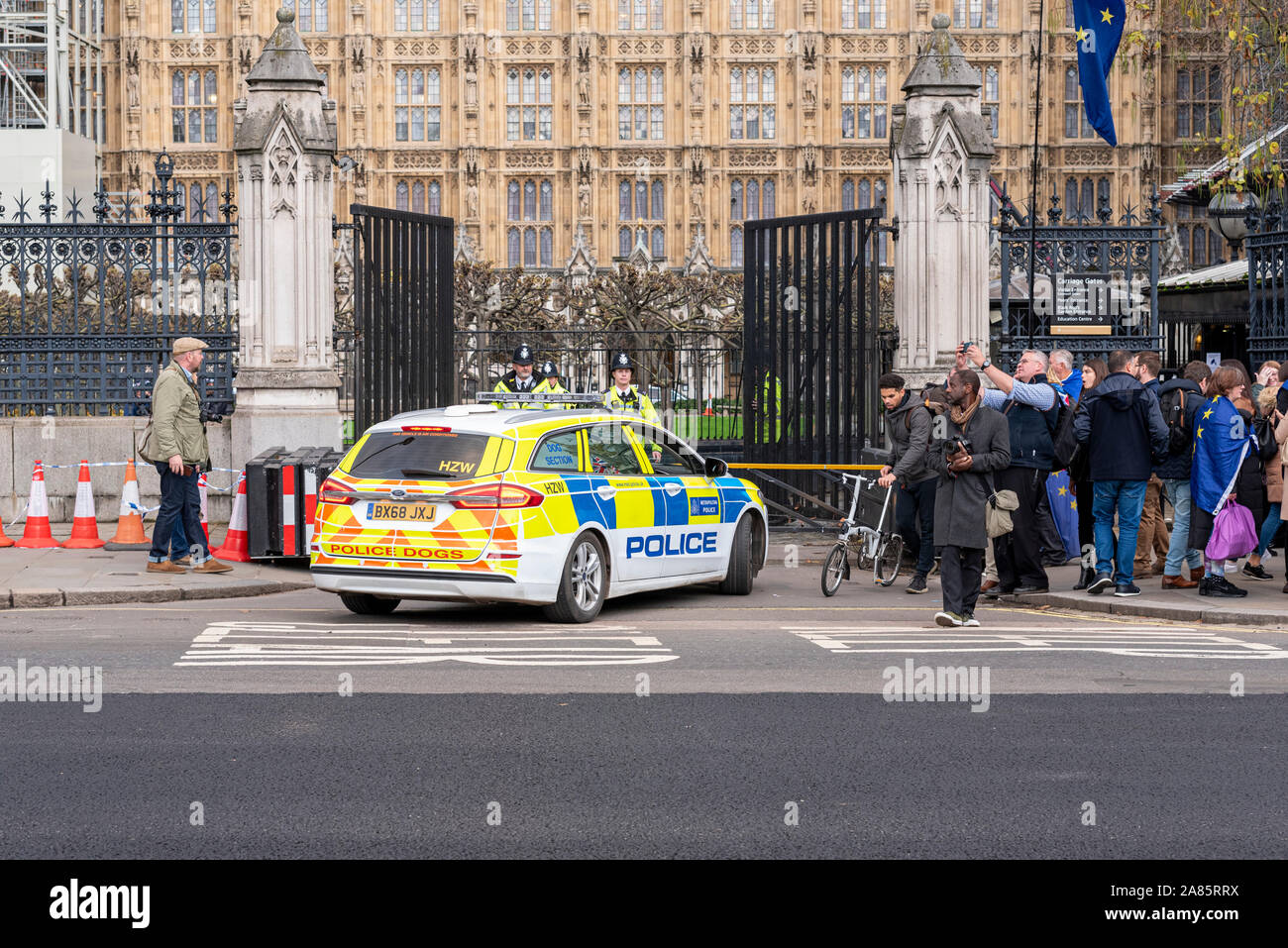 Polizeiauto in den Häusern des Parlaments Tor. Palast von Westminster Sicherheit mit Offizieren und Menschen. Brexit protestieren gegen EU-Flaggen Stockfoto