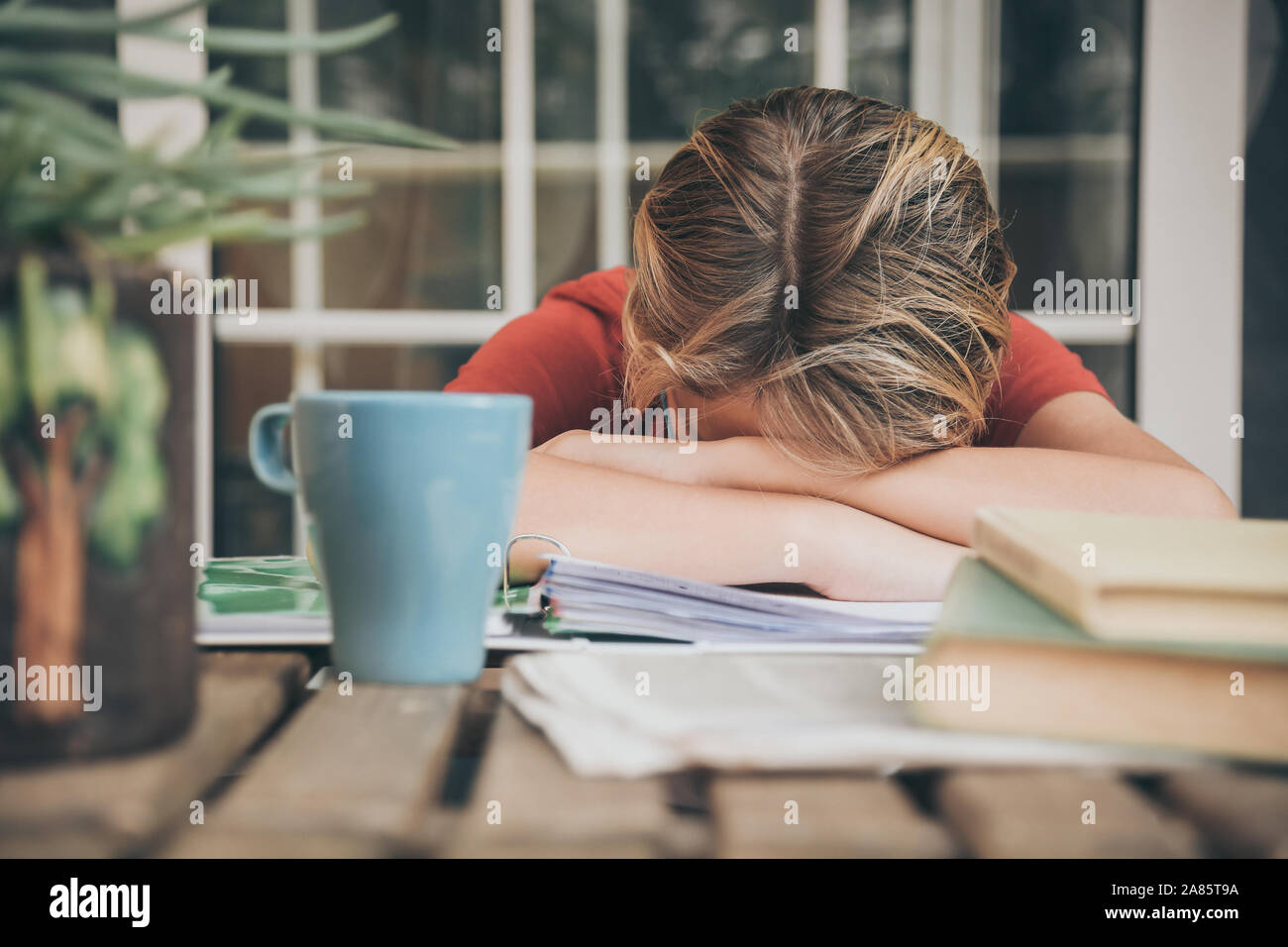 Müde Schüler Hausaufgaben zu Hause sitzen im Freien mit Schule Bücher und Zeitungen. Junge müde wegen der schweren studieren. Kind schlafend auf dem copybook Stockfoto