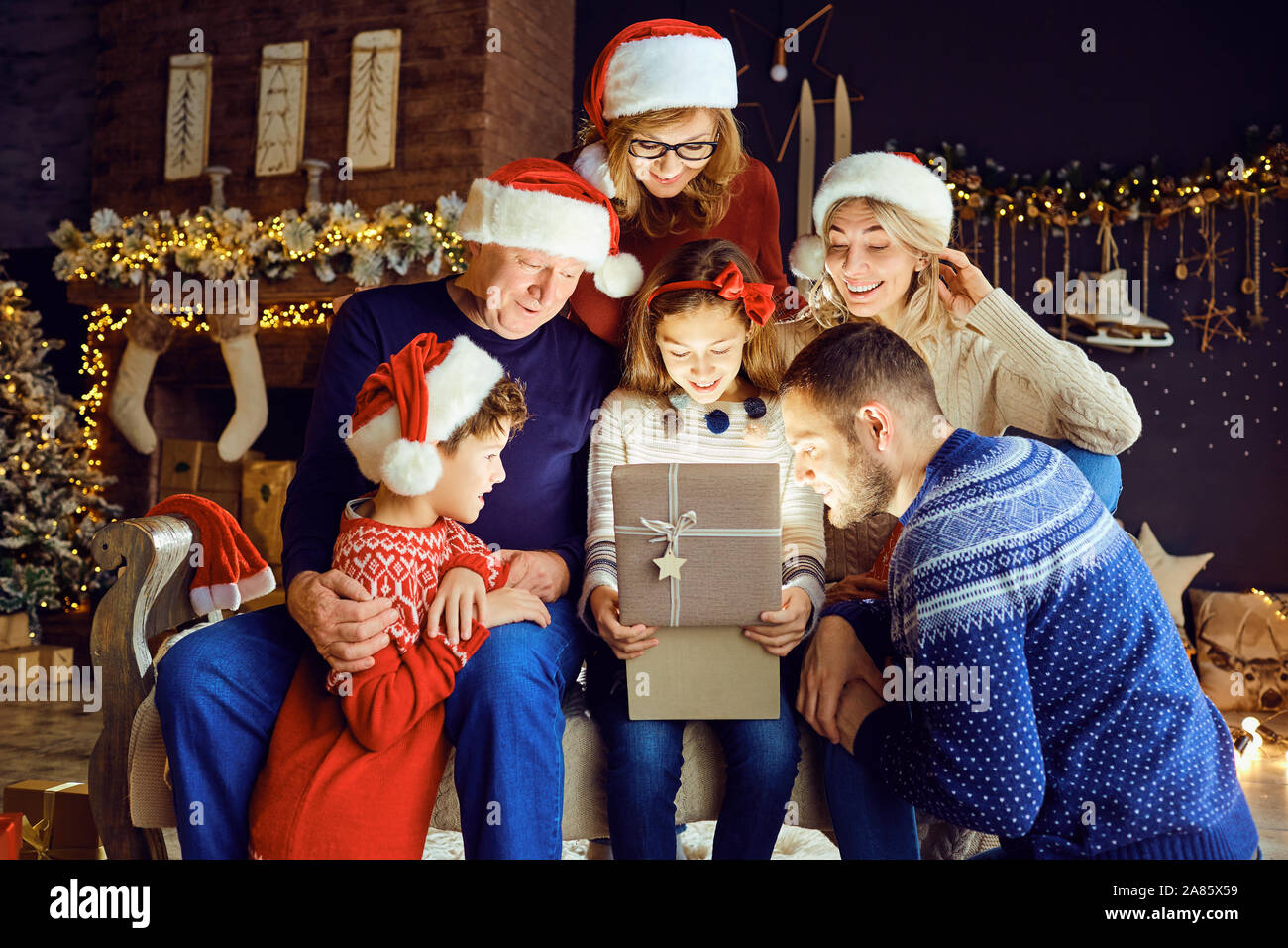 Eine große Familie in einem Zimmer gibt Geschenke zu Weihnachten. Stockfoto